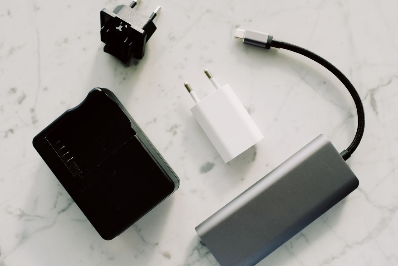 About A collection of electronic adapters and cables on a marble surface, showcasing tech essentials.